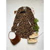 flat lay of animal print dress beige trainers and purse