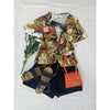 flat lay of tropical print top and black shorts
