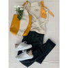 flat lay of black trousers, cream jumper, yellow bag and white trainers