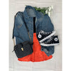 flat lay of orange skirt, denim jacket, black top, black converse and black bag