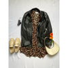 flat lay of animal print dress, black leather jacket and shoes