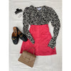 flat lay of black and white top, pink skirt, black shoes and beige bag
