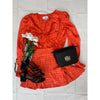 flat lay of orange top and skirt with bag and black shoes