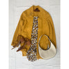 flat lay of animal print dress, yellow coat and cream bag