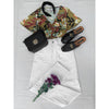 flat lay of tropical print top and white jeans